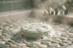 Shower steamer tablet fizzing with steam rising on a shower floor