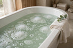 Bathtub filled with pale sage-green coloured bath water