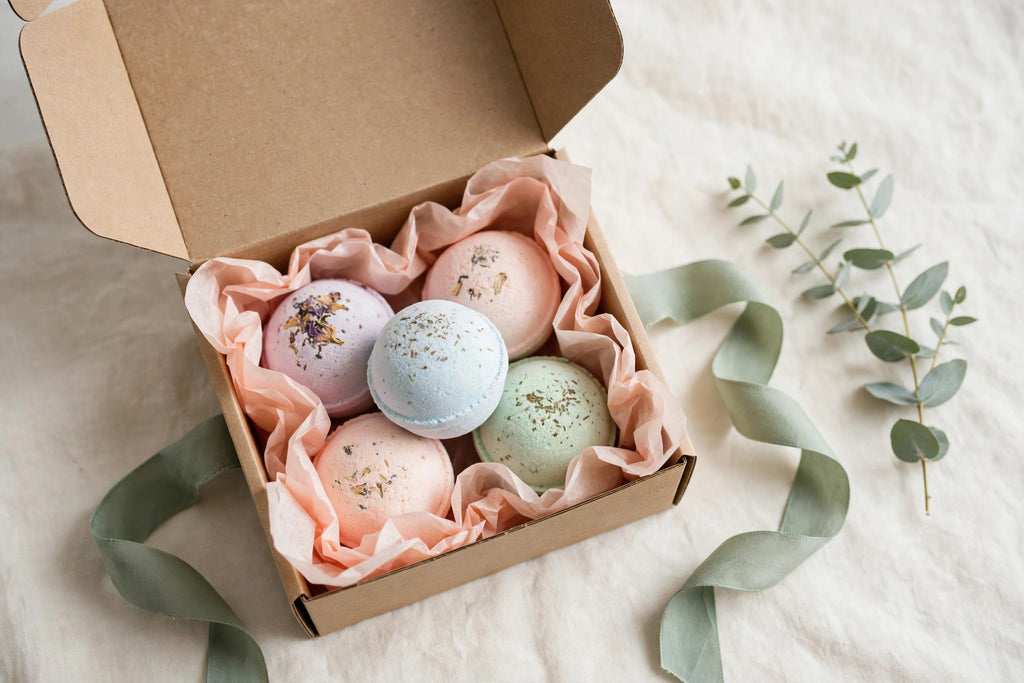 Open gift box of pastel bath bombs with ribbon