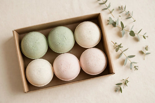 Bath bombs in pastel shades in a plain open gift box