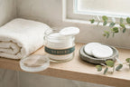 Nurtura toner pads jar on a bathroom shelf with pads on a stone dish